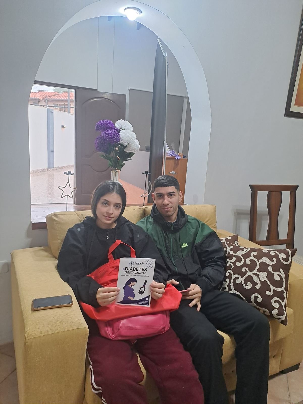 Una pareja en la sala de espera con la guía sobre diabetes gestacional